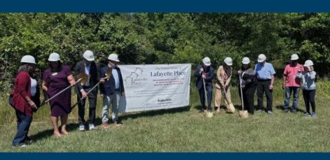 Senators, the Delaware governor, Milford's Mayor, NeighborWorks President & CEO Marietta Rodriguez join staff from Interfaith Community Housing of Delaware Inc., at the groundbreaking of Lafeyette Place. The photo shows the dignitaries lined up and carying shovels in front of a line of trees.