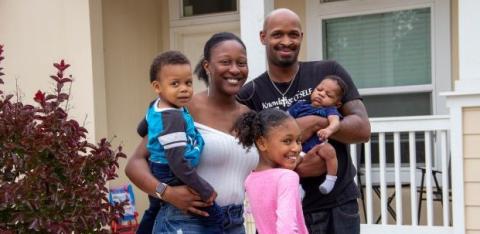 A family stands in front of their new hope, with thanks to NHPS.
