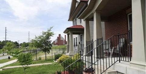 A home with a neat porch and other homes in the distance.